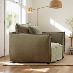 a living room scene with focus on the couch and floor lamp in the foreground