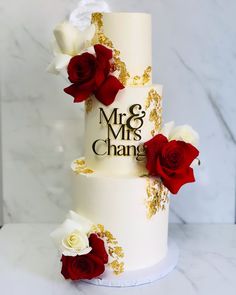 a wedding cake decorated with red and white flowers