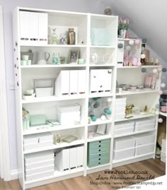 a white bookcase filled with lots of shelves and drawers next to a wall mounted clock