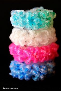 four different colored bracelets stacked on top of each other in the shape of flowers