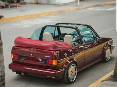 a red convertible car parked on the side of the road