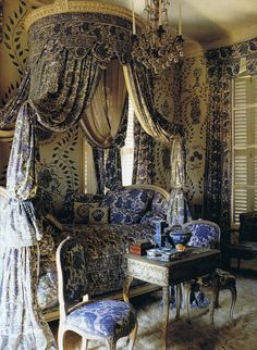 an ornate bedroom with four poster bed and chandelier hanging from the ceiling, decorated in blue and white