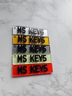 four key tags with the words ms keys in black, white, yellow and red