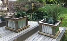 two planters sitting on top of a wooden deck