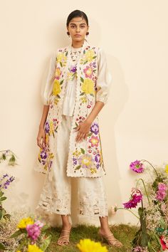 Ivory chanderi long jacket with all over multi color floral applique, thread embroidery and cut work embroidered details.
Components: 1
Pattern: Embroidered
Type Of Work: Floral Applique, Cut Work and Thread Work
Neckline: Open
Sleeve Type: Sleeveless
Fabric: Chanderi
Color: Ivory
Other Details: 
Cut work hem
Panelled jacket
Note: The inner top and pant worn by the model is not for sale
Occasion: Party - Aza Fashions Patch Work Top, Long Kurti Patterns, Panel Jacket, Linen Embroidery, Kurti Embroidery Design, Floral Patches, Ivory Fabric, Balloon Sleeve Top, Fashion Forecasting