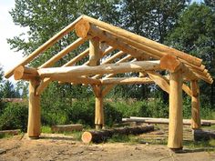 a wooden structure made out of logs in the woods