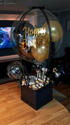 a birthday cake with balloons and confetti on it in front of a television