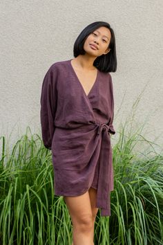 Woman wearing Linen wrap tulip hem dress Daisy in shadow purple color Chic V-neck Midi Dress With Tie Fastening, V-neck Tie Waist Dress For Daywear, Chic V-neck Belted Dress For Day Out, Elegant Belted Mini Dress For Daywear, Fall V-neck Midi Dress With Tie Waist, Mini Length Tie Back Dress For Fall, Tie Back Mini Dress For Fall, Fall Mini Length Dresses With Tie Back, Belted V-neck Wrap Dress For Day Out