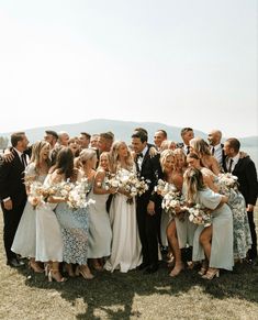 a group of people standing next to each other on top of a grass covered field