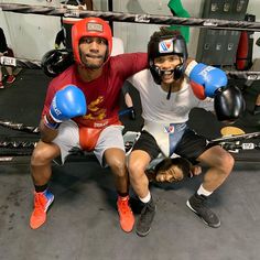 two men in boxing gear posing for the camera