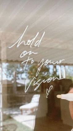 the reflection of a woman in a window holding a paper plate with writing on it