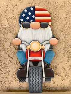 a statue of santa claus on a motorcycle with the american flag painted on it's face