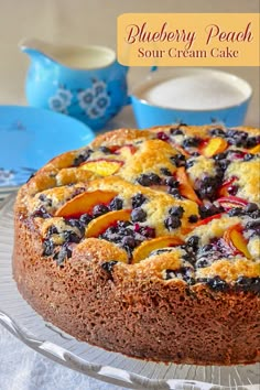 a blueberry peach sour cream cake on a glass platter