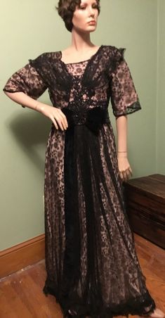 This exquisite vintage gown is a true masterpiece of the Edwardian era. The dress features a stunning combination of Black Chantilly lace, a pink silk underskirt, with velvet and Jet bead trim. The dress is a size Small and has a Chest Size of 35" and Waist Size of 28" with 12" sleeves. The dress measures 44" from the waist to hem, with a Shoulder to Hem length of 56.5" and Shoulder to Shoulder length of 14.5". The gown is an original piece from around 1910. The dress is ideal for vintage enthus Antique Dress, Vintage Gowns, Edwardian Era, Chantilly Lace, Beaded Trim, Pink Silk, Formal Occasion, Beautiful Gowns, Dress Clothes For Women