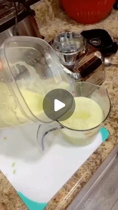 a person pouring liquid into a bowl on top of a counter next to a blender