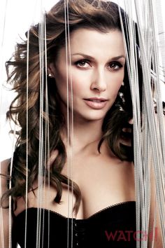 a woman with long hair is posing for a magazine cover shot, covered in strands of thread