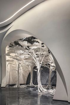 the interior of an art museum with white arches and trees