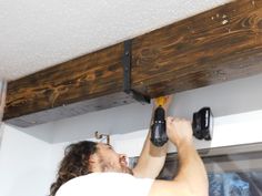 a man is working on the ceiling in his kitchen