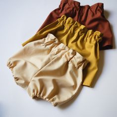 three different colored pants laying on top of each other