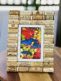 a wine cork photo frame sitting on top of a wooden table