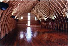 the inside of a building with wooden floors and beams on the ceiling is made of wood planks