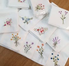 a pile of embroidered napkins sitting on top of a wooden table