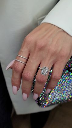 a woman's hand with two rings on her finger and one ring in the middle