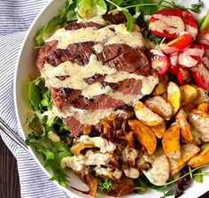 a plate with steak, potatoes and salad on it