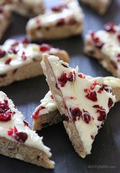 several pieces of cake with white frosting and cranberries