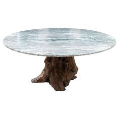 a round marble table with a tree stump base