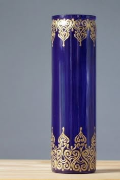 a blue and gold vase sitting on top of a wooden table