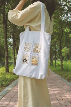 a woman is talking on her cell phone while carrying a tote bag with pictures