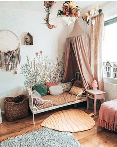 a bedroom with a canopy bed, rugs and flowers on the wall above it