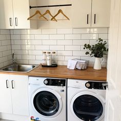 a washer and dryer sitting in a kitchen next to each other on top of a wooden counter