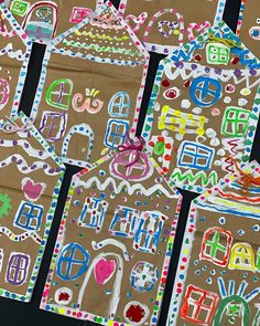 several gingerbread houses made out of paper and colored crayons on brown paper