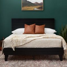 a bedroom with green walls and a bed in the middle is decorated with brown throw pillows