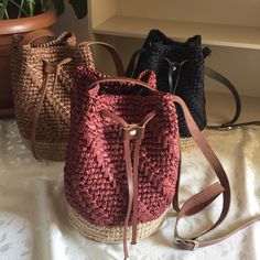 three purses sitting on top of a white table