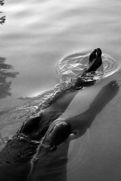 a person floating in the water with their feet up