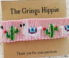 a pink bracelet with green, blue, and red beads is on top of a card that reads the grina hippie thank you for your purchase