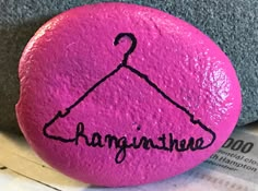 a pink rock with the word hangin'twe on it and a black outline