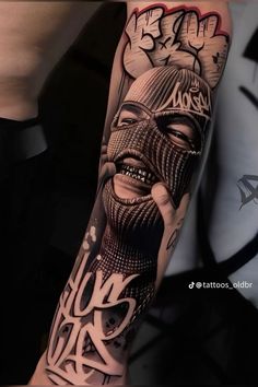 a man's arm covered in tattoos with an image of a person wearing a mask