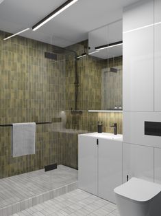 a bathroom with green tiled walls and flooring, including a white toilet next to a walk in shower