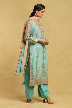 Aqua kurta with blossom print and thread embroidered placket. Paired with palazzo and dupatta.
Components: 3
Pattern: Printed, Embroidery
Type Of Work: Thread, floral
Neckline: Round
Sleeve Type: Long sleeves
Fabric: 80 % Cotton  20% Silk
Color: Blue
Other Details: 
Tassel bordered dupatta
Occasion: Puja - Aza Fashions Kurta Palazzo Set, Printed Embroidery, Ritu Kumar, Palazzo Set, Blossom Print, Fashion App, Set For Women, Cotton Silk, Aza Fashion