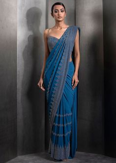 Draped pre-stitched tulle sari embellished with tonal embroidery with matching embroidered blouse. Embroidered Draped Lehenga For Wedding, Embroidered Draped Traditional Wear For Wedding, Embroidered Draped Traditional Wedding Wear, Elegant Embroidered Draped Saree, Embroidered Draped Dupatta For Party, Embroidered Silk Pre-draped Saree For Evening, Fitted Blue Pre-draped Saree With Intricate Embroidery, Traditional Embroidered Draped Blouse Piece, Designer Embroidered Draped Saree