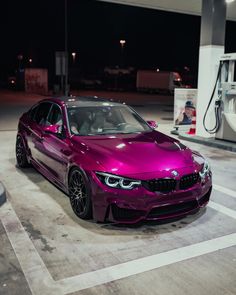 a purple car is parked at a gas station