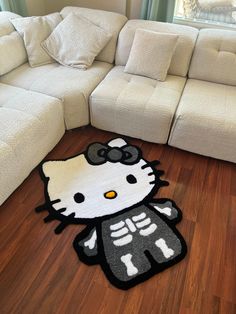 a hello kitty rug on the floor next to a couch