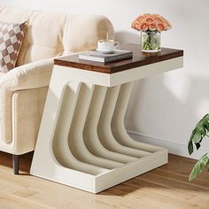 a coffee table with a book on it next to a couch and potted plant