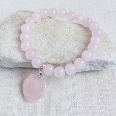 This bracelet for girls or women made of 8mm Rose Quartz beads. Bracelet is crafted on a strong latex-free stretchy cord so as to slip on to your wrist easily. This bracelet is perfect for someone who loves natural gemstone jewelry.  Heart charm are symbols of faith, love, and good luck.  Rose Quartz is the stone of unconditional love and infinite peace. It is the most important crystal for the heart and the heart chakra. It teaches the true essence of love. Rose Quartz purifies and opens the heart at all levels, and brings deep inner healing and self-love. It is calming, reassuring and excellent for use in trauma or crisis. Rose quartz encourages you to trust, value, accept and forgive yourself. Order your exact wrist size in inches plus 0.2 inch for a comfortable fit, if you want the bra Pink Heart Bracelet, Symbols Of Faith, Bracelet For Girls, Heart Chakra Healing, Bracelet With Heart, Jewelry Heart, Faith Love, Rose Quartz Bracelet, Rose Quartz Heart