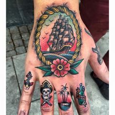 a person's hand with tattoos on it and a ship in the middle of their palm