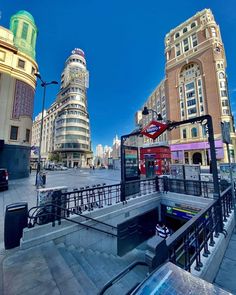 the city is full of tall buildings and some people are walking down the steps in front of them